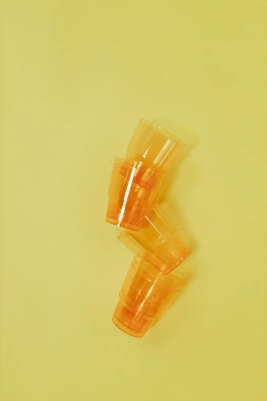 a couple of cups sitting on top of a table, by Doug Ohlson, photorealism, yellow-orange, abstract photography, 2000s, 🍸🍋