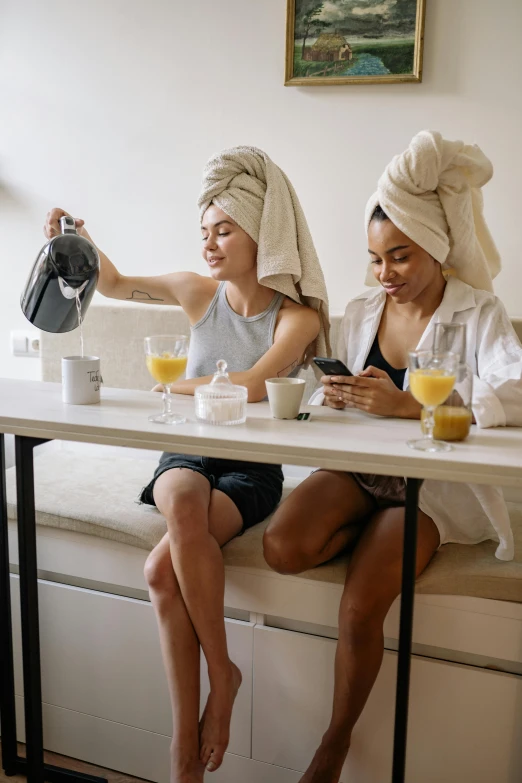 two women sitting at a table with towels on their heads, trending on pinterest, lesbian, drinks, apartment, ponytails