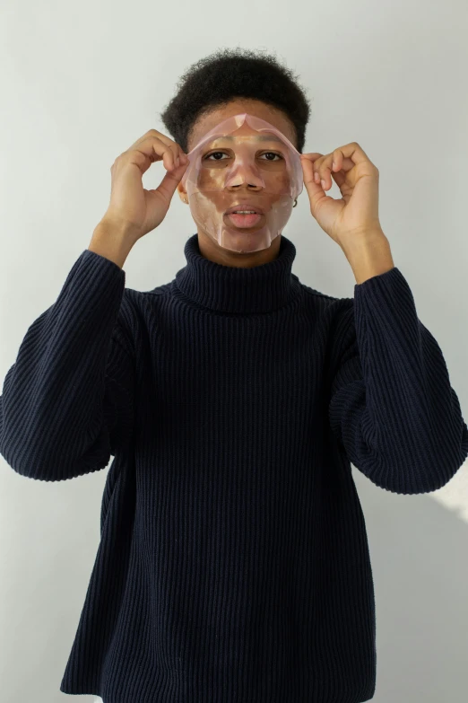 a woman covering her eyes with a pair of glasses, by Ellen Gallagher, featured on reddit, renaissance, clear [[bronze]] face [mask], man is with black skin, photoshoot for skincare brand, on clear background