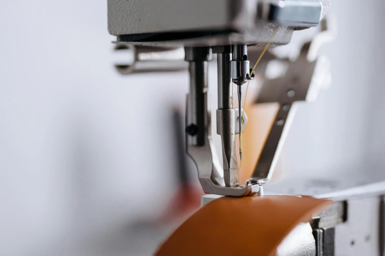 a close up of a machine with a piece of leather on it, unsplash, process art, instagram photo, premium quality, ribbon, 3 / 4 wide shot