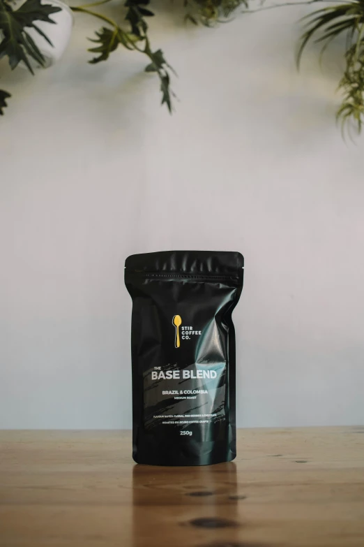 a bag of coffee sitting on top of a wooden table, space base, front label, textured base ; product photos, graeme base