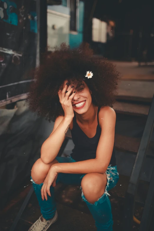 a woman with a flower in her hair, pexels contest winner, large black smile, frizzy hair, sitting down, multiple stories