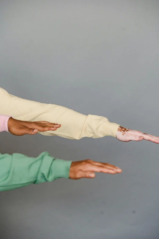 a man and a woman doing a handstand pose, an album cover, trending on pexels, pastel clothing, single pair of hands, off - white collection, diverse colors