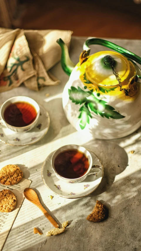 a tea pot sitting on top of a table next to cups of tea, a still life, by Pamela Ascherson, pexels, slim aarons, soup, jamaican, ocher