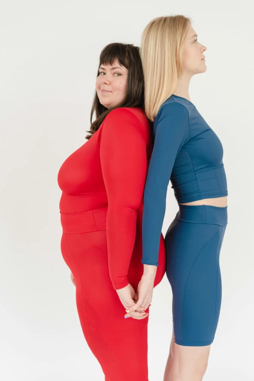 a couple of women standing next to each other, inspired by Vanessa Beecroft, pexels contest winner, renaissance, cropped red yoga short, blue and red two - tone, overweight, in spandex suit