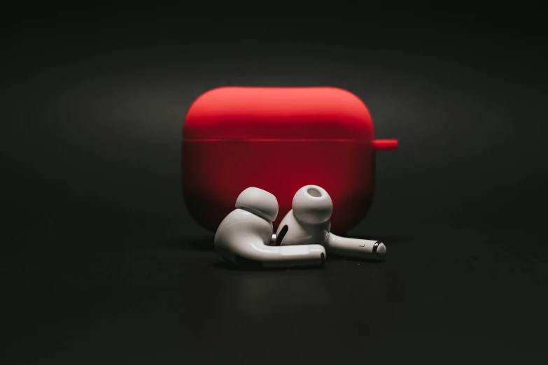 a pair of airpods sitting on top of a table, by Niels Lergaard, trending on pexels, graffiti, red suit, case, monochrome 3 d model, people at work