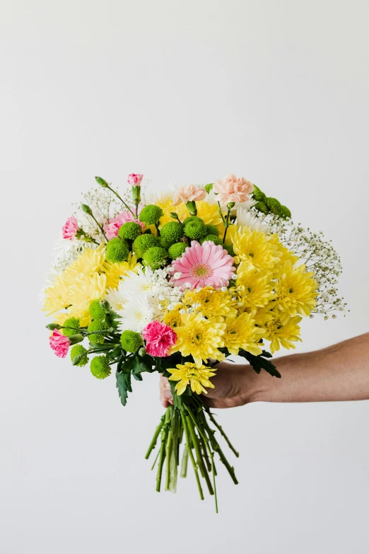 a person holding a bunch of yellow and pink flowers, a pastel, inspired by François Boquet, unsplash, chrysanthemum and hyacinth, highly polished, lightweight, fully covered