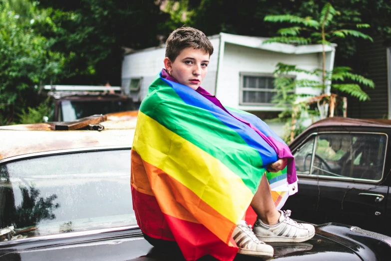 a young boy sitting on the hood of a car, by Meredith Dillman, trending on pexels, renaissance, lgbt flag, loving stare, grand finale, multi - coloured