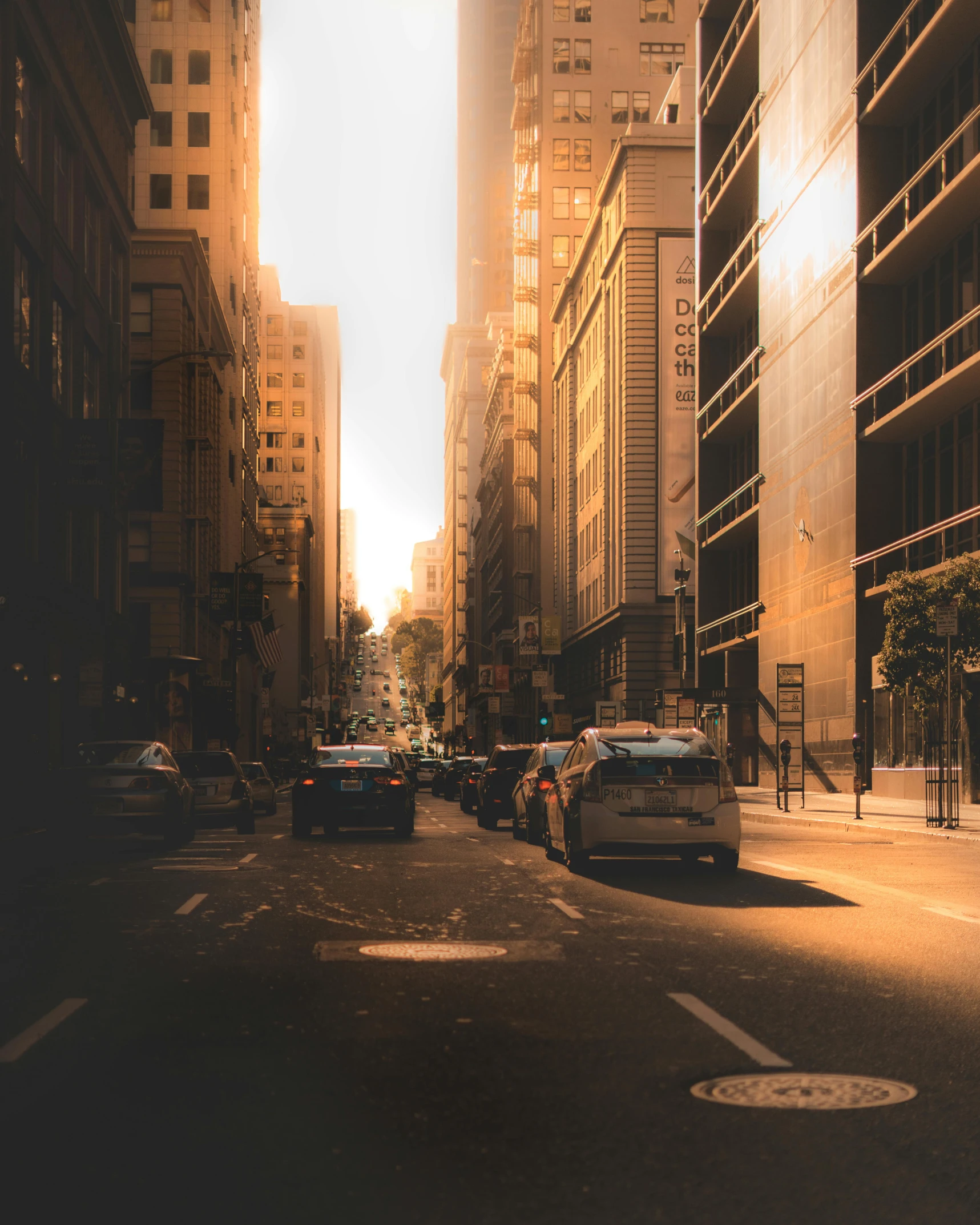 a city street filled with lots of tall buildings, an album cover, pexels contest winner, sun shines down on the car, beige and dark atmosphere, summer morning light, quiet street