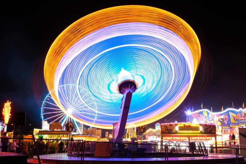 a ferris wheel spinning in the dark at night, by Matthias Stom, pexels contest winner, bright colors ultrawide lens, avatar image, flying saucer, orange and cyan lighting