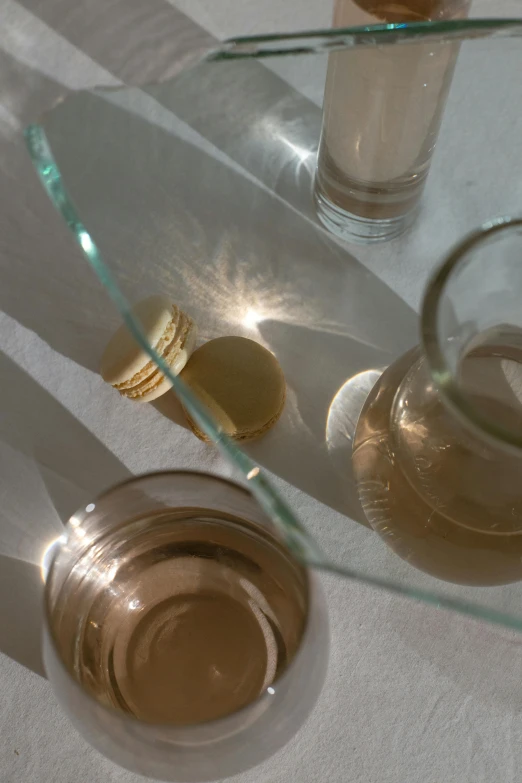 a couple of glasses sitting on top of a table, by Nina Hamnett, partially gold, morning detail, translucent, ilya ozornin