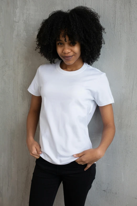 a woman standing against a wall with her hands in her pockets, a portrait, trending on unsplash, plain white tshirt, sport t-shirt, various sizes, no - text no - logo