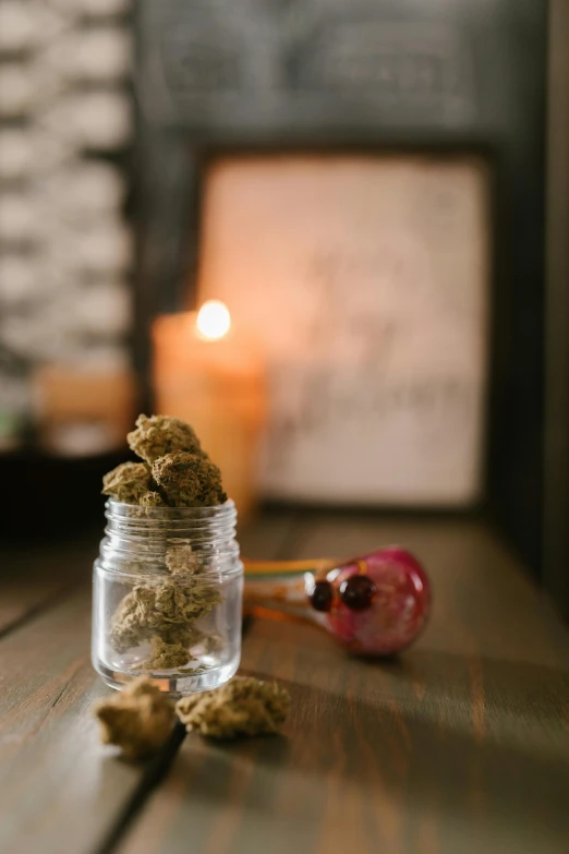 a jar of marijuana sitting on top of a wooden table, a portrait, unsplash, lit candles, profile image, flower buds, snacks