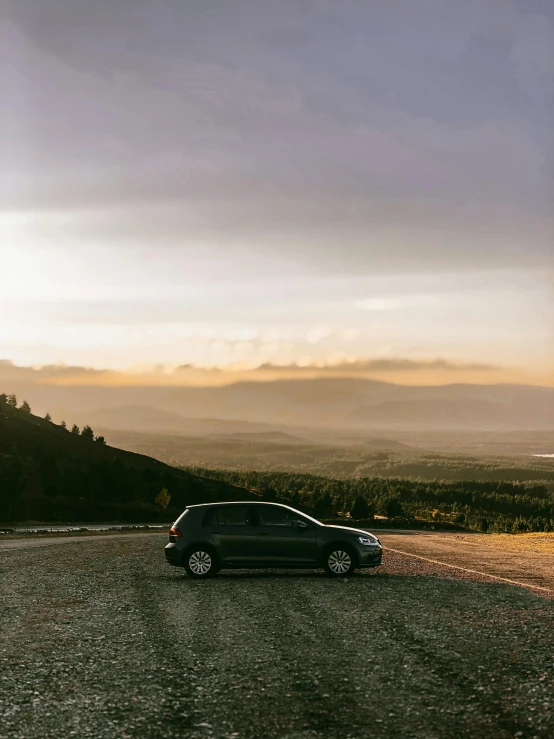 a car is parked on the side of the road, by Hallsteinn Sigurðsson, golden hour sunset lighting, high-quality photo, on a hill, trending photo