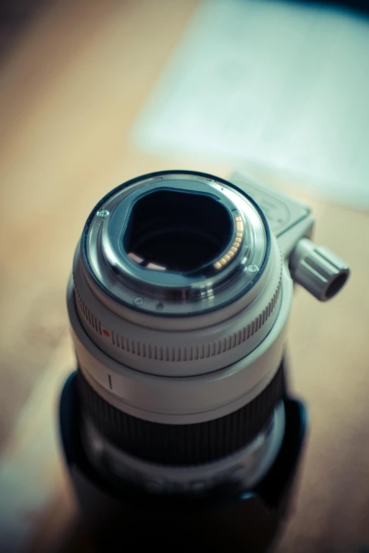 a close up of a camera lens on a table, by Adam Manyoki, lensflare, leica s photograph, a high angle shot, shot on sony a 7