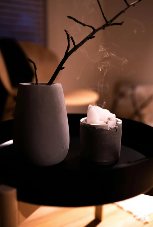 a black tray sitting on top of a wooden table, inspired by Einar Hakonarson, unsplash, dry ice, cozy candlelight, marshmallow, sitting in a lounge