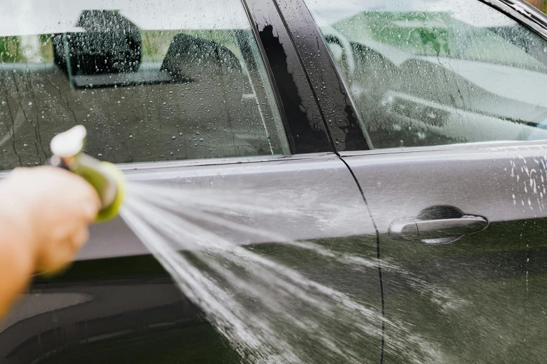 a person spraying a car with a hose, ultradetailedl, extra wide, thumbnail, cleanest image