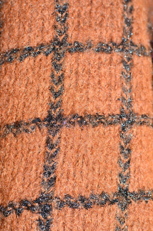 a close up of a rug on a wooden floor, orange and black, ( ( ( copper ) ) ) wire whiskers, detailed plaid miniskirt, detailed product shot