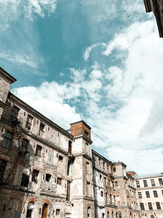 a man riding a skateboard up the side of a building, by Lucia Peka, pexels contest winner, renaissance, city ruins background, abandoned polish mansion, panoramic, blue sky above