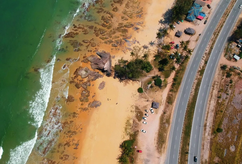 an aerial view of a beach next to the ocean, pexels contest winner, hurufiyya, sri lankan mad max style, thumbnail, summer street near a beach, rock and sand around