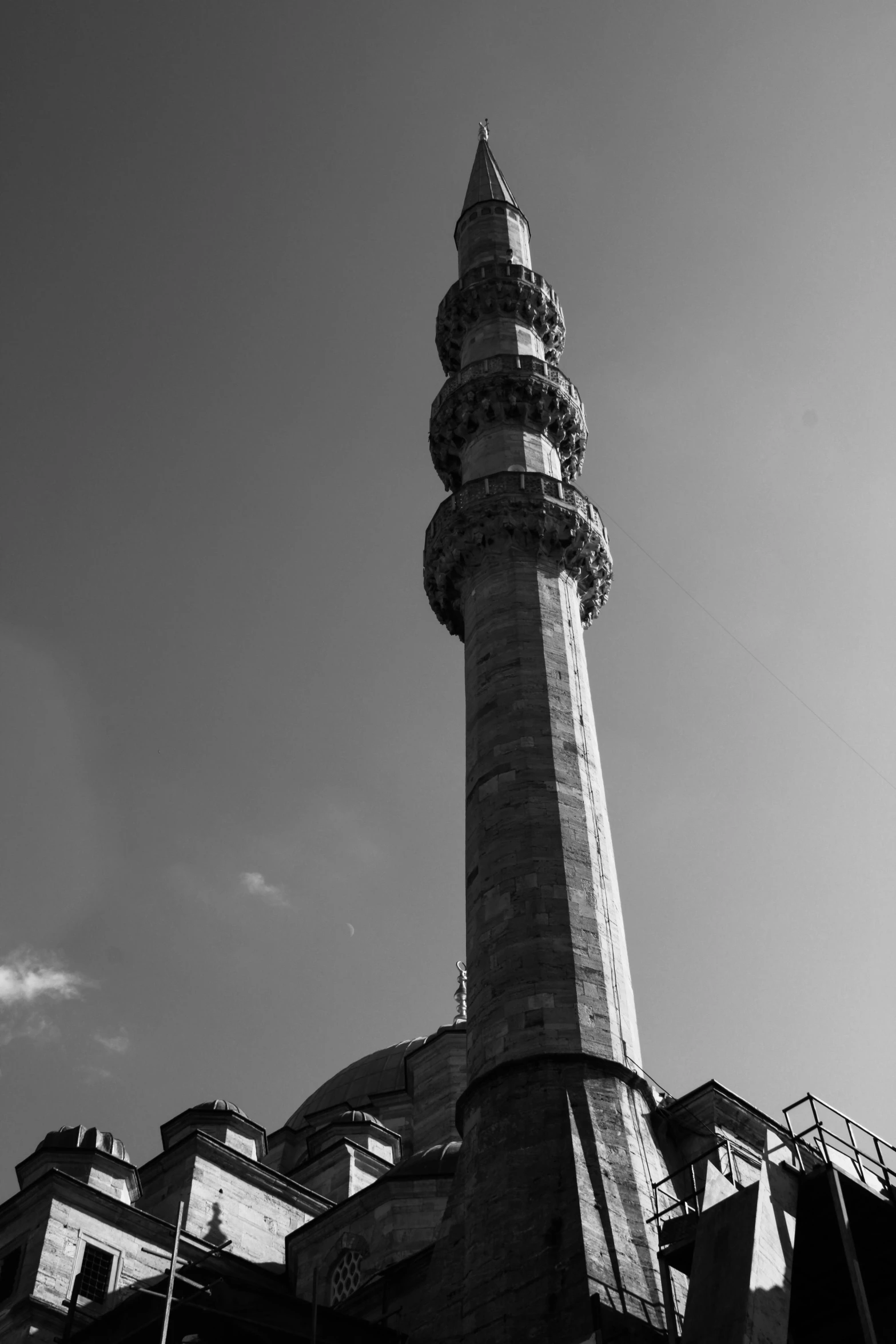 a black and white photo of a tall building, inspired by Altoon Sultan, hurufiyya, lead - covered spire, blue sky, turkey, square