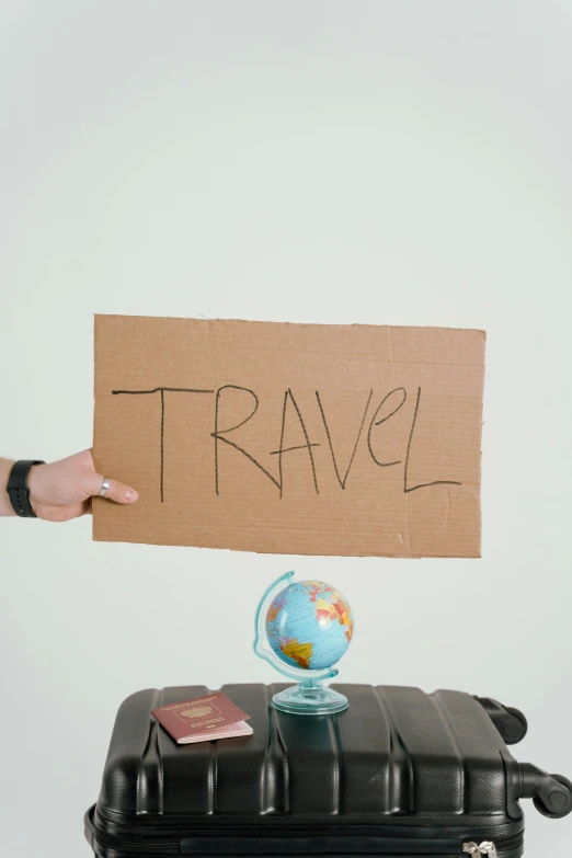 a person holding a sign that says travel, thumbnail, cardboard, profile image, 2 0 5 6