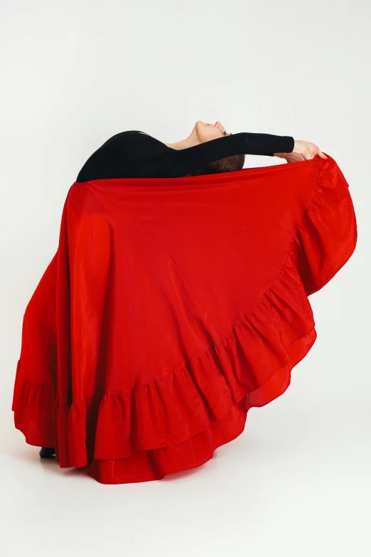 a woman in a black top and red skirt, by Juan O'Gorman, pexels, arabesque, with a white background, shawl, square, stretch