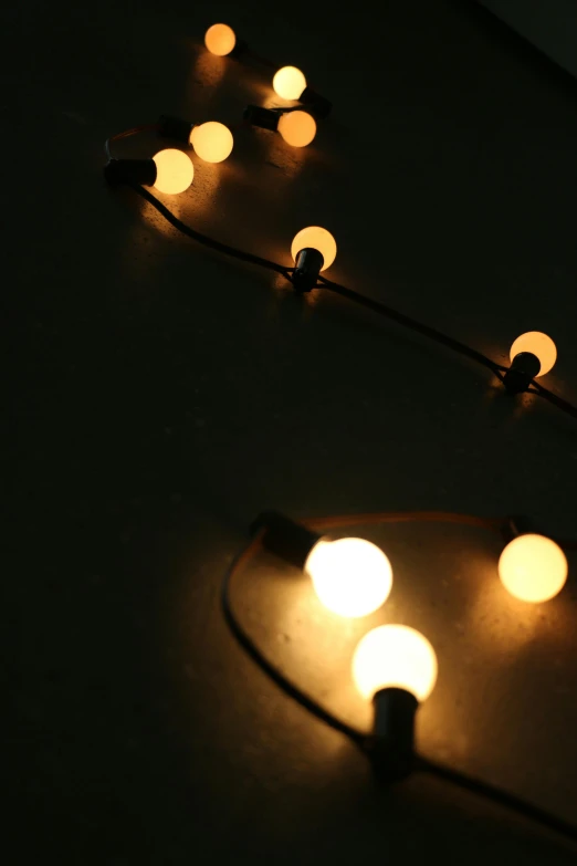 a group of lights that are on a table, cords, atmospheric lighting - n 9, gallery lighting, string lights