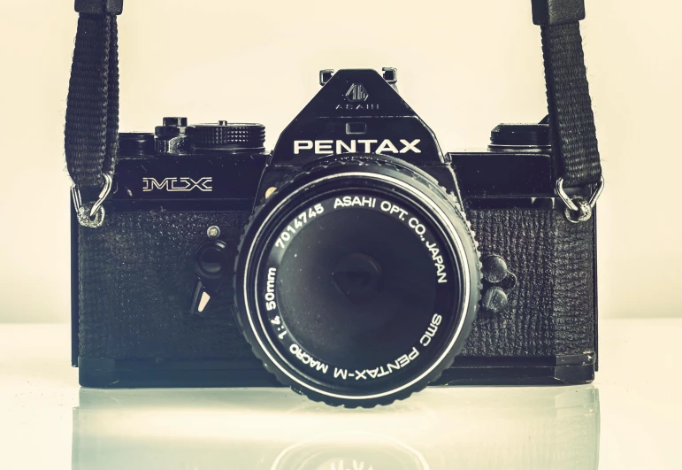 a black camera sitting on top of a table, pexels contest winner, photorealism, pentax, in retro colors, instagram picture, vintage soft grainy