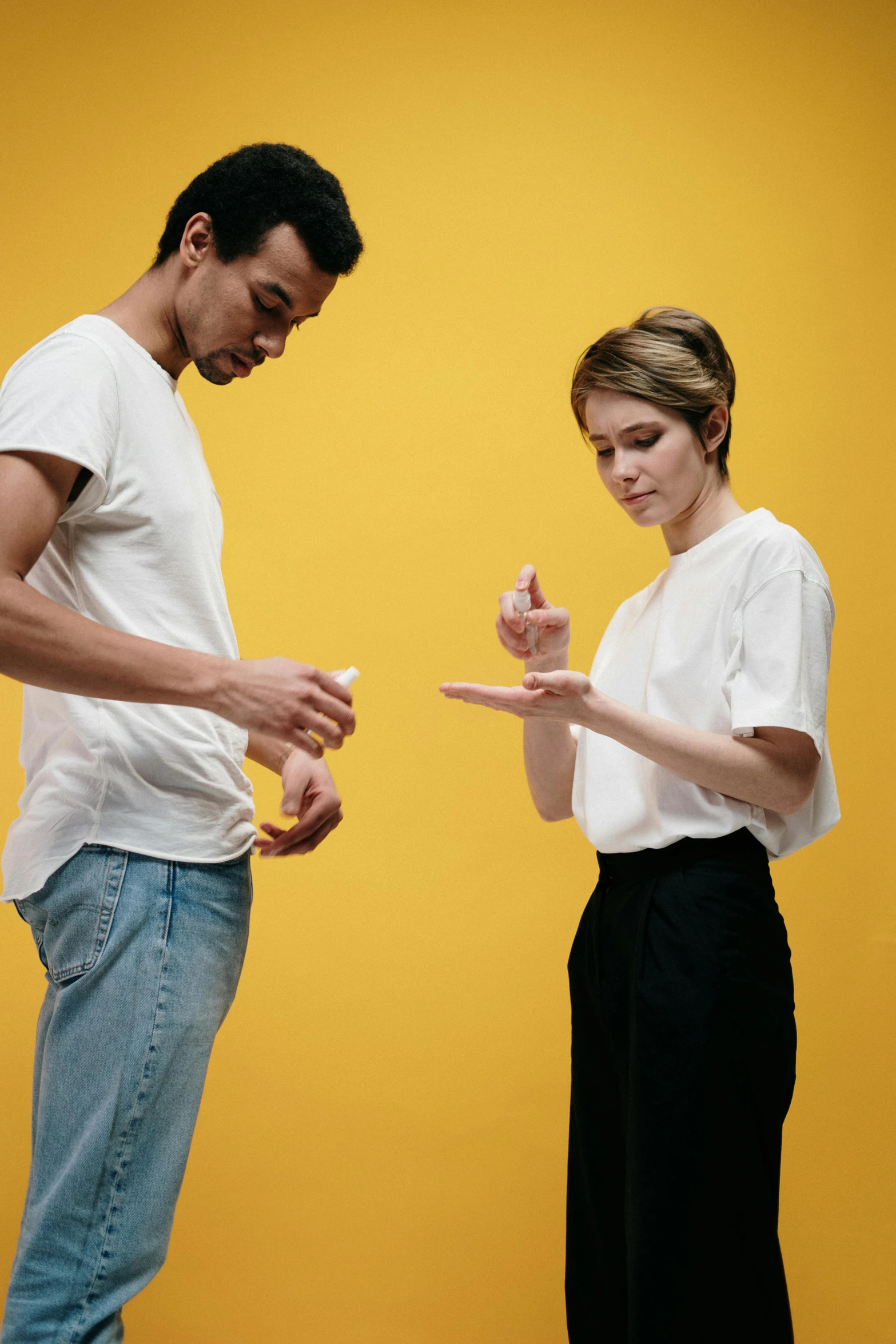 a man and a woman standing next to each other, by Adam Marczyński, offering the viewer a pill, card game, non binary model, ocher