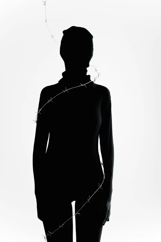 a silhouette of a woman standing in front of a white background, inspired by Marina Abramović, barbed wire, wearing turtleneck, neck chains, press shot