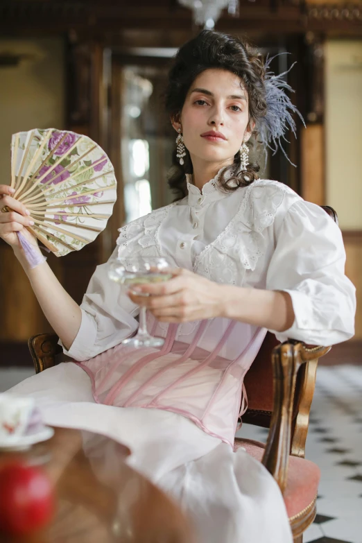 a woman sitting in a chair holding a fan, a portrait, inspired by Konstantin Somov, rococo, lookbook, natalia dyer, slide show, drinking