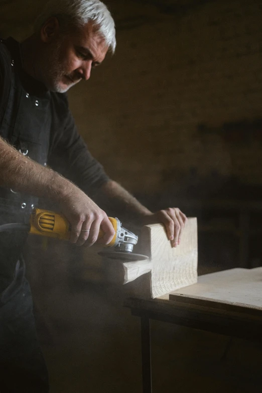 a man using a power drill on a piece of wood, by Jan Tengnagel, arbeitsrat für kunst, cinematic image, manly design, commercial photograph, lachlan bailey