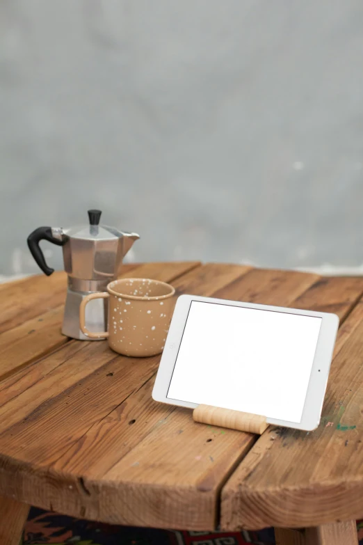 a tablet computer sitting on top of a wooden table, inspired by Jan Müller, table in front with a cup, bamboo, product display, small