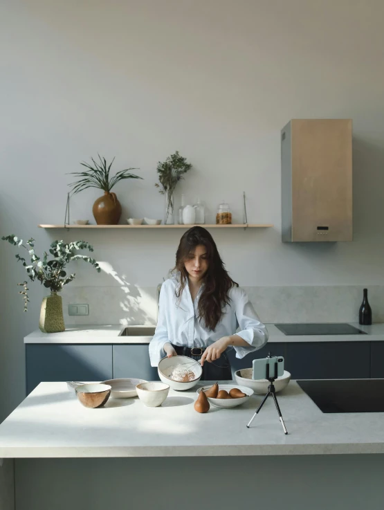 a woman standing in a kitchen preparing food, inspired by Wilhelm Hammershøi, pexels contest winner, portrait of priyanka chopra, low quality video, modern minimalist f 2 0, full body profile camera shot