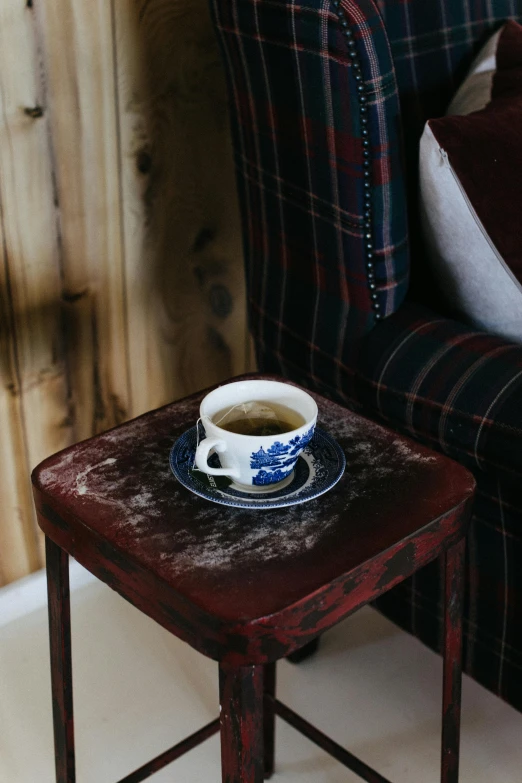 a small table with a cup of coffee on it, old couch, secret tea society, scottish, multiple stories