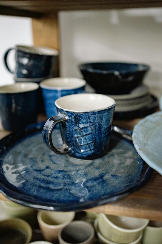 a close up of plates and cups on a table, by Fuller Potter, midnight blue, homemade, thumbnail, small