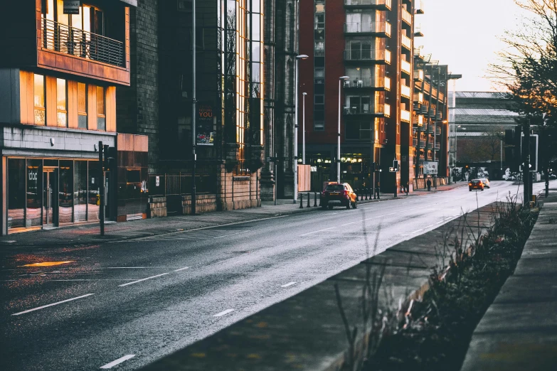 a city street filled with lots of tall buildings, inspired by Elsa Bleda, pexels contest winner, empty road, early morning, manchester, thumbnail