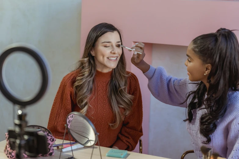 a woman getting her make - up done in front of a mirror, a portrait, trending on pexels, photorealism, lucy hale and maisie williams, promotional image, while smiling for a photograph, avatar image