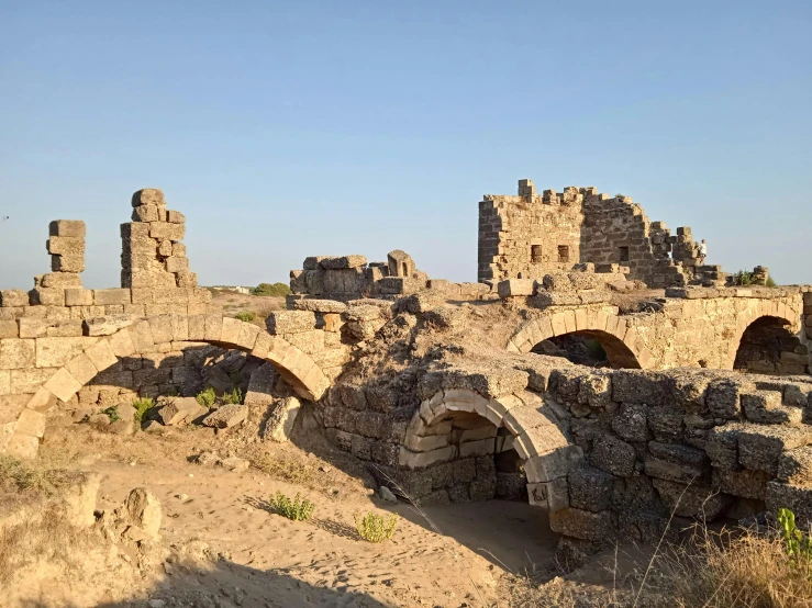 there is a stone bridge in the middle of the desert, byzantine ruins, thumbnail, medieval coastal village, white wall complex