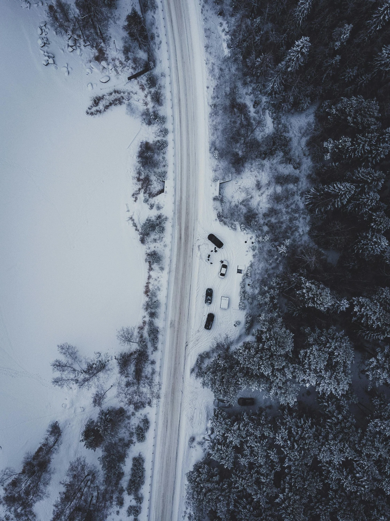 a car driving down a snowy road next to a forest, by Christen Dalsgaard, pexels contest winner, land art, bird\'s eye view, cars parked underneath, thumbnail, (3 are winter