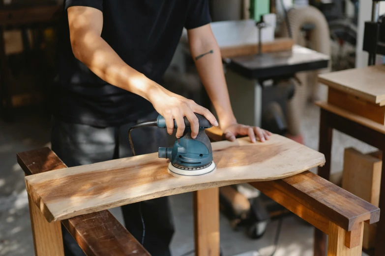 a man sanding a piece of wood with a sander, pexels contest winner, 9 9 designs, avatar image, curved body, plating