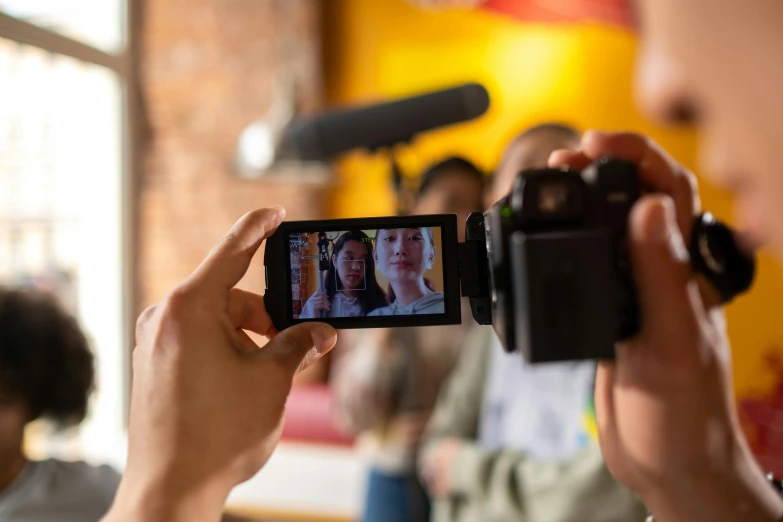 a person taking a picture with a camera, unsplash, video art, holding a microphone, close up to the screen, sony 175mm”, group photo