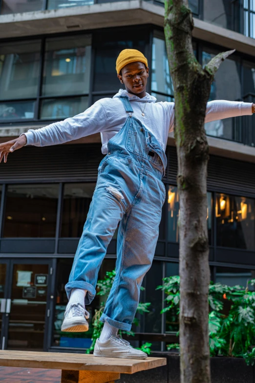 a man standing on top of a wooden bench, by Lee Gatch, happening, blue overalls, riyahd cassiem, swing on a tree, wearing nike air mags