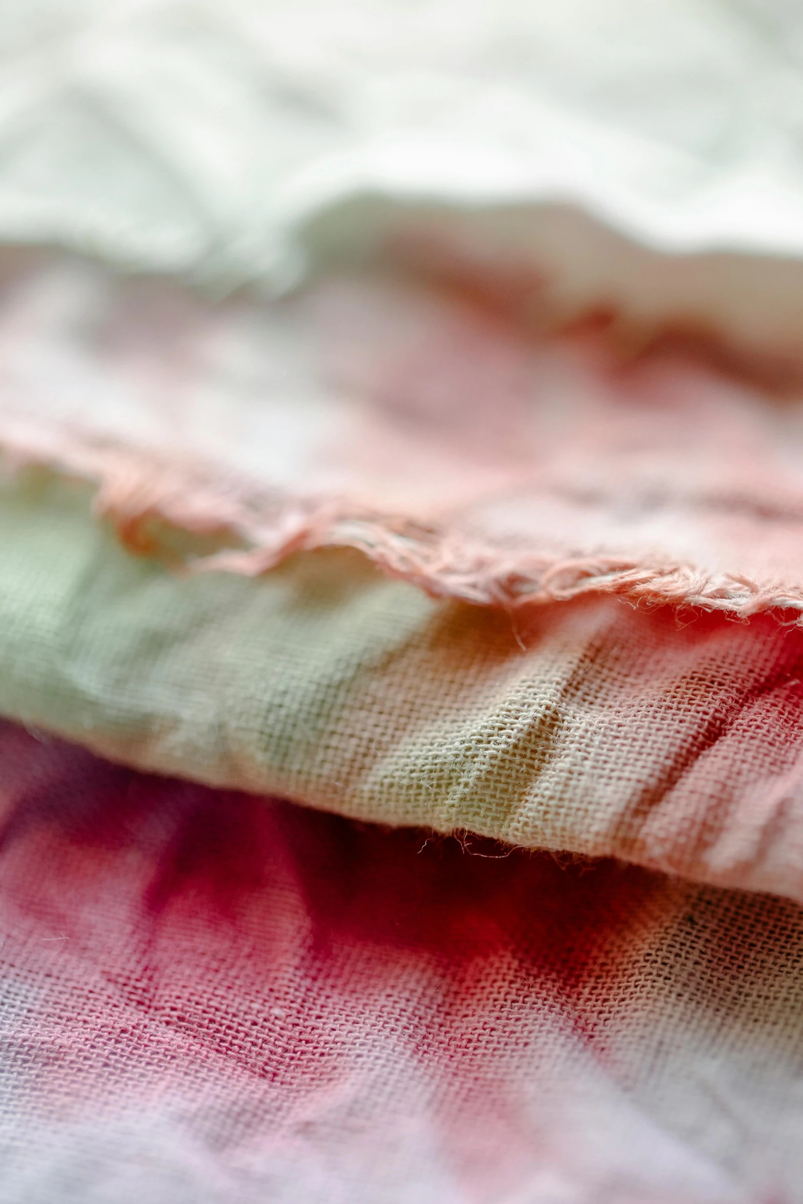 a close up of a piece of fabric on a table, by Helen Biggar, unsplash, process art, pink and green colour palette, faded red colors, three colors, made of glazed