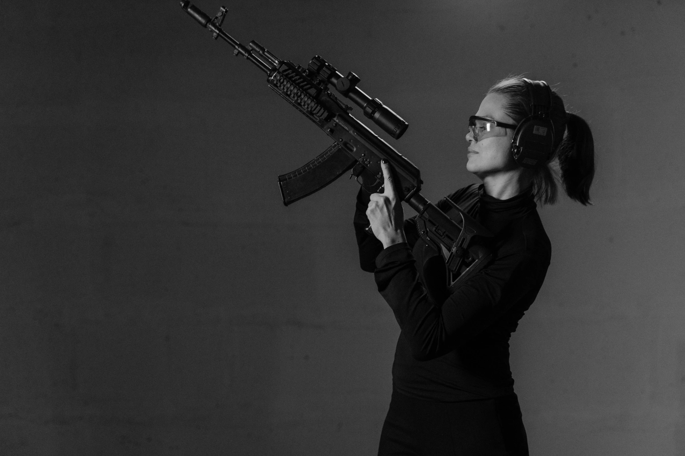 a black and white photo of a woman holding a gun, by Emma Andijewska, holding ar-15, profile picture 1024px, ilya golitsyn, posed