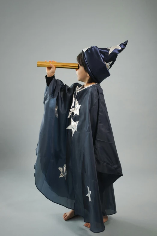 a little boy dressed up in a wizard costume, an album cover, featured on reddit, magical realism, yukata clothing, magic wooden staff, on a gray background, magic star