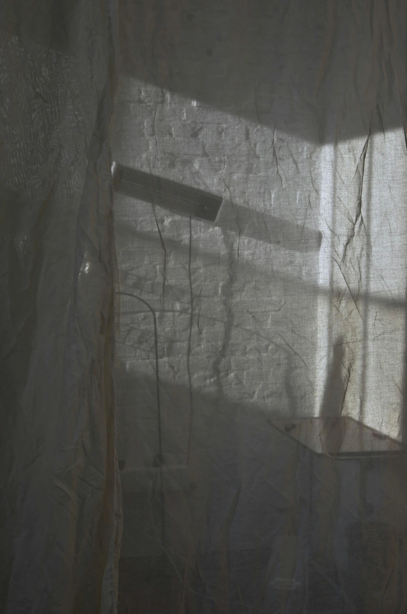 a white toilet sitting in a bathroom next to a window, by Camille Souter, light and space, transparent veil, shaft of sun through window, tattered fabric, texture detail