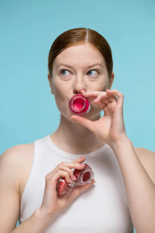 a woman holding a lip bale in front of her mouth, pexels contest winner, renaissance, vibrant vials, bubblegum body, awkwardly holding red solo cup, product design shot