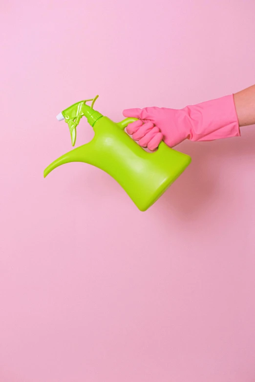 a person in pink gloves holding a green watering can, by Paul Bird, pexels contest winner, plasticien, clean background, pastel', clean medical environment, made of liquid